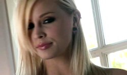Long-legged blonde in black strings stimulates her snatch on the couch