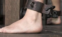 Sexually Broken brunette in metal shackles is sucking a fat dick