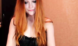 Hot-looking redhead girl is slowly undressing on the webcam