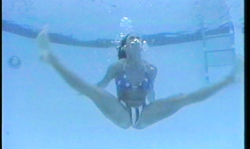 Beautiful smiling brunette dances underwater with passion