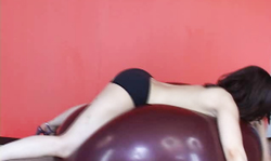 Dark-haired babe in short blue dress jumps on a balloon