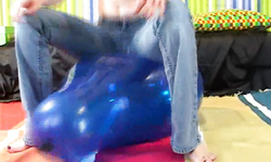 Perfect redhead in tight blue jeans jumps on a blue balloon