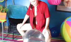 Awesome smiling girl is jumping on a massive transparent balloon