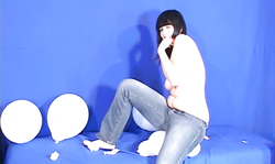 Brunette in blue jeans is jumping on the big balloons