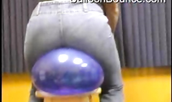 Astonishing lady in black jeans rides a big blue balloon