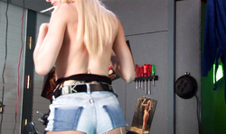 Blonde in denim shorts poses topless in the garage